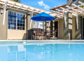Thumbnail 4 of 44 - the pool and patio of a house with a pool table and umbrella