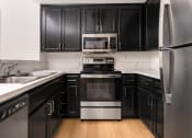 Thumbnail 34 of 44 - a kitchen with black cabinets and stainless steel appliances