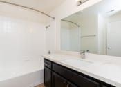 Thumbnail 37 of 44 - a bathroom with a sink and a shower and a mirror