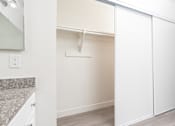 Thumbnail 20 of 38 - A white closet with a white door and a white shelf.