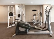 Thumbnail 11 of 13 - a gym with cardio equipment and weights on the floor