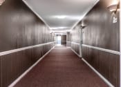 Thumbnail 12 of 13 - a hallway with wood paneled walls and a red carpet