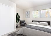 Thumbnail 4 of 38 - A bedroom with a large bed and a chair.