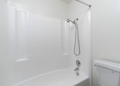Thumbnail 22 of 38 - A white bathroom with a tub and shower.