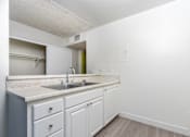 Thumbnail 16 of 38 - A kitchen with white cabinets and a sink.