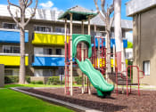 Thumbnail 4 of 13 - a playground in front of a building with a slide