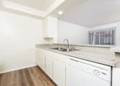 Thumbnail 9 of 17 - A kitchen with white cabinets and a white dishwasher.