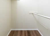 Thumbnail 15 of 17 - A white wall with a wooden floor and a white rail.