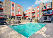 Thumbnail 5 of 17 - an apartment building with a pool in front of it