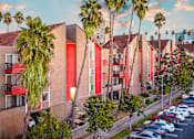 Thumbnail 4 of 17 - a row of townhomes with palm trees and parked cars