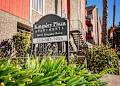 Thumbnail 6 of 17 - a sign for kingsley plaza apartments in front of a building