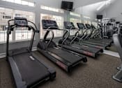 Thumbnail 9 of 36 - A gym with treadmills and elliptical machines.