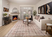 Thumbnail 11 of 36 - A living room with a fireplace and a couch.