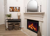 Thumbnail 13 of 36 - A fireplace with a mirror above it and two baskets on the floor.