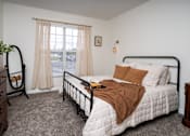 Thumbnail 17 of 36 - A bedroom with a bed, nightstand, and window.