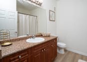 Thumbnail 18 of 36 - A bathroom with a sink, toilet, and a mirror.