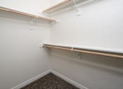 Thumbnail 20 of 36 - A corner of a room with a carpeted floor and two shelves.