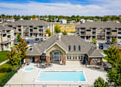 Thumbnail 2 of 36 - A large house with a pool in front of apartment buildings.