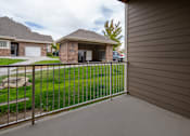 Thumbnail 22 of 36 - A house with a grey fence and a green lawn.