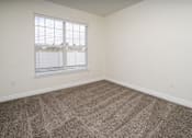 Thumbnail 27 of 36 - A room with a carpeted floor and a window with blinds.