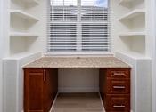 Thumbnail 30 of 36 - A small home office with a desk and drawers.