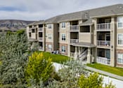 Thumbnail 36 of 36 - A large apartment complex with a mountain in the background.
