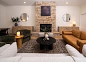 Thumbnail 6 of 36 - A living room with a fireplace and a couch.
