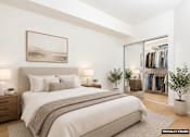 Thumbnail 9 of 27 - A bedroom with a large bed, a painting on the wall, and a wardrobe with clothes.