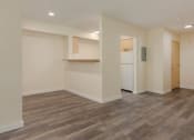 Thumbnail 27 of 27 - an empty living room with a kitchen in the background