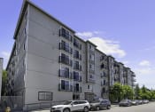 Thumbnail 11 of 20 - a large apartment building with cars parked in front of it at King Arthurs Court, Seattle, 98125