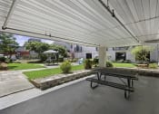 Thumbnail 14 of 20 - a covered patio with a picnic table and courtyard area in the background at King Arthurs Court, Seattle, 98125