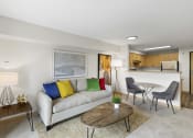 Thumbnail 17 of 22 - a living room with a couch, table, and a bistro set and a kitchen in the background at Villaggio Apartment Homes, Tacoma, WA