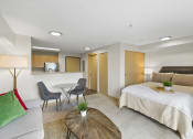 Thumbnail 16 of 22 - Studio Apartment with Cozy Living Area, Bedroom with Recessed Lighting, and View of Kitchen and Dining Area at Villaggio Apartment Homes, WA 98402