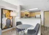 Thumbnail 20 of 22 - Dining Space with cozy set u with a table and two chairs and a kitchen in the background at Villaggio Apartment Homes, Tacoma