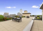 Thumbnail 12 of 22 - Resident Rooftop Lounge with tables and chairs and a view of the city at Villaggio Apartment Homes, Tacoma, Washington 98402