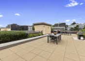 Thumbnail 5 of 22 - a roof top lounge space with a dining table and chairs at Villaggio Apartment Homes, Washington, 98402