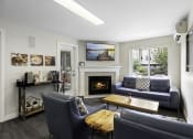 Thumbnail 14 of 19 - a living room with couches, wooden coffee table, and a fireplace at Willows Court Apartment Homes, Washington, 98125