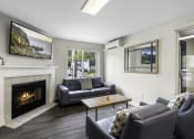 Thumbnail 6 of 19 - Spacious Living room with cozy seating areas, a coffee table, and a fireplace complete with a mantle at Willows Court Apartment Homes, Washington