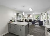 Thumbnail 10 of 19 - a kitchen with a large island and view into the living room in the background at Willows Court Apartment Homes, Seattle, 98125