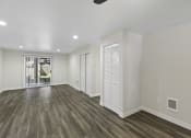 Thumbnail 14 of 18 - Spacious Living Room with Plank Flooring and White Walls and Recessed Lighting at Park 210 Apartment Homes, Edmonds, Washington