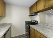Thumbnail 10 of 18 - Kitchen with Granite Countertops and Wooden Cabinets at Park 210 Apartment Homes, Washington, 98026