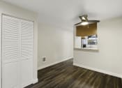 Thumbnail 15 of 18 - Large Open Living Room with Plank Flooring, a Window Area into the Kitchen and a Coat Closet at Park 210 Apartment Homes, Edmonds, 98026