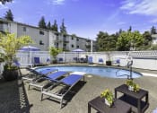 Thumbnail 25 of 25 - a pool with lounge chairs and umbrellas at the enclave at woodbridge apartments in sugar