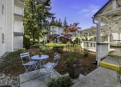 Thumbnail 8 of 25 - a patio with two chairs and a table in front of a building