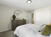Thumbnail 24 of 25 - a bedroom with a white bed and a dresser with a potted plant