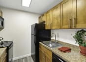 Thumbnail 19 of 25 - a kitchen with wooden cabinets and black appliances
