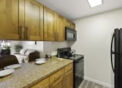 Thumbnail 21 of 25 - a kitchen with wooden cabinets and a granite counter top