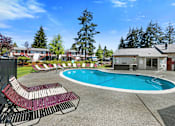 Thumbnail 8 of 23 - Large Pool with Lounge Chairs and Trees in the Background at Pinewood Square Apartment Homes, Washington, 98087