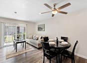 Thumbnail 13 of 23 - Spacious Open Space Living Room with Plank Flooring, Sliding Glass Door, and Overhead Ceiling Fan at Pinewood Square Apartment Homes, WA 98087