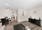 Thumbnail 21 of 23 - An Inviting Living and Dining Room Area with a Ceiling Fan and Hardwood Floors at Pinewood Square Apartment Homes, Lynnwood